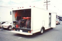 Everything has a place. To make the most of available space rear deck of race car is secured to side of truck